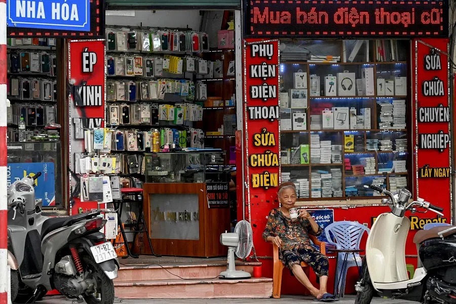 A woman sits in front of an electronics store in Hanoi on 6 June 2025. Vietnam’s exports rose sharply last month, official figures showed 6 June, as the communist country tries to negotiate relief from swingeing tariffs threatened by US President Donald Trump.  (Nhac Nguyen/AFP)