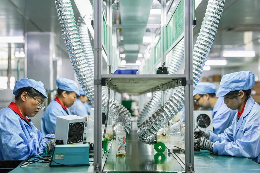 Employees work on a production line of an electric car charging station at a factory in Ruichang, Jiangxi province, China, on 9 July 2025.