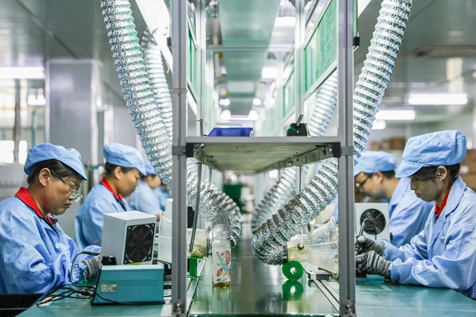 Employees work on a production line of an electric car charging station at a factory in Ruichang, Jiangxi province, China, on 9 July 2025. (AFP)