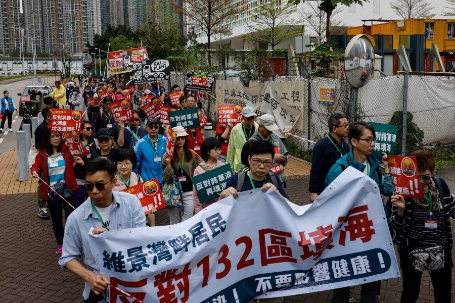 Protesters are required to wear numbered lanyards around their necks as they protest against a land reclamation and waste transfer station project during one of the first demonstrations to be formally approved since the enactment of a sweeping national security law, in Hong Kong, China, 26 March 2023. (Tyrone Siu/Reuters)