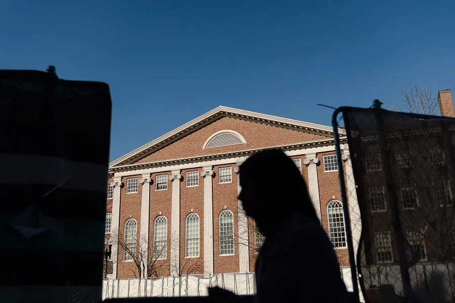 People walk past Harvard University in Harvard Square on 17 April 2025 in Cambridge, Massachusetts, US.