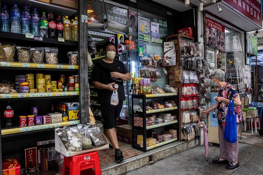 In this picture taken on 13 May 2022, a man leaves a store in Hong Kong. (Isaac Lawrence/AFP)