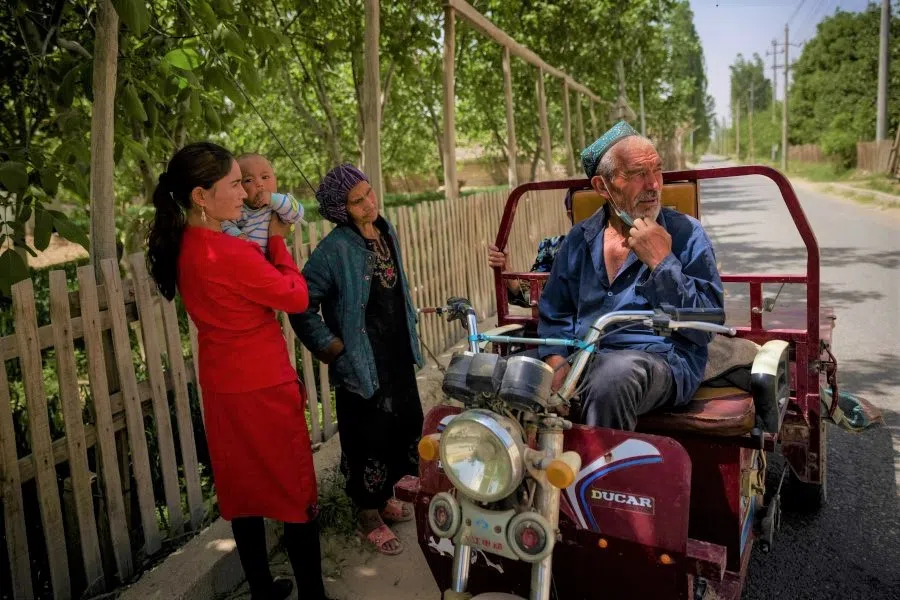 Villagers stand in a rural settlement outside Hotan, Xinjiang Uyghur Autonomous Region, China, 29 April 2021. (Thomas Peter/Reuters)