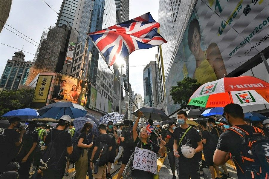 A protester waves the British flag outside SOGO at Causeway Bay, in Hong Kong, on 28 July 2019. (SPH Media)