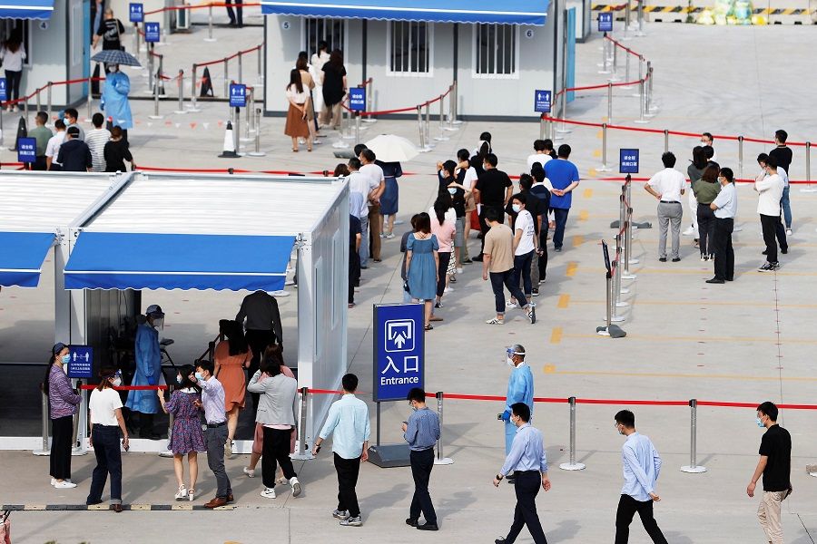 Staff members of Shanghai Pudong International Airport line up at a nucleic acid testing site to test for the Covid-19 coronavirus in Shanghai, China, 20 August 2021. (CNS photo via Reuters)