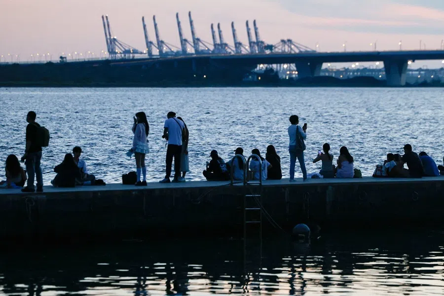 People watch the sunset along the waterfront in New Taipei City, Taiwan, 9 July 2026.