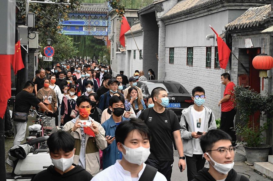 People walk in an alley during the country's national Golden Week holiday in Beijing, China, on 2 October 2021. (Jade Gao/AFP)
