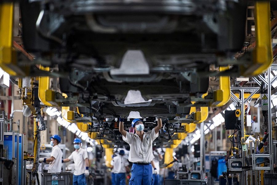 This photo taken on 18 May 2022 shows an employee working on an assembly line at an auto plant in Wuhan, Hubei province, China. (AFP)