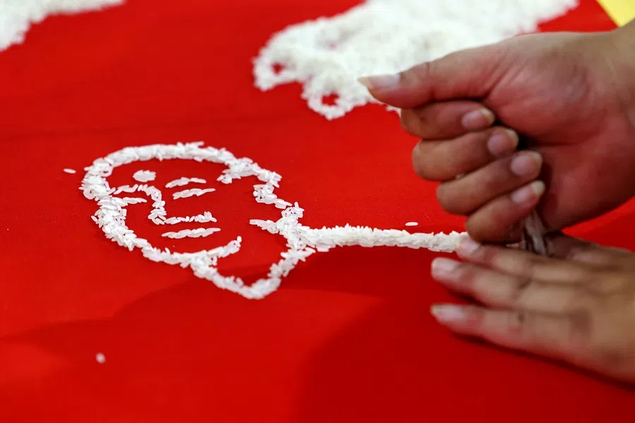 Tan arranges rice drawings directly based on visual estimation, without making any markings or drafts.