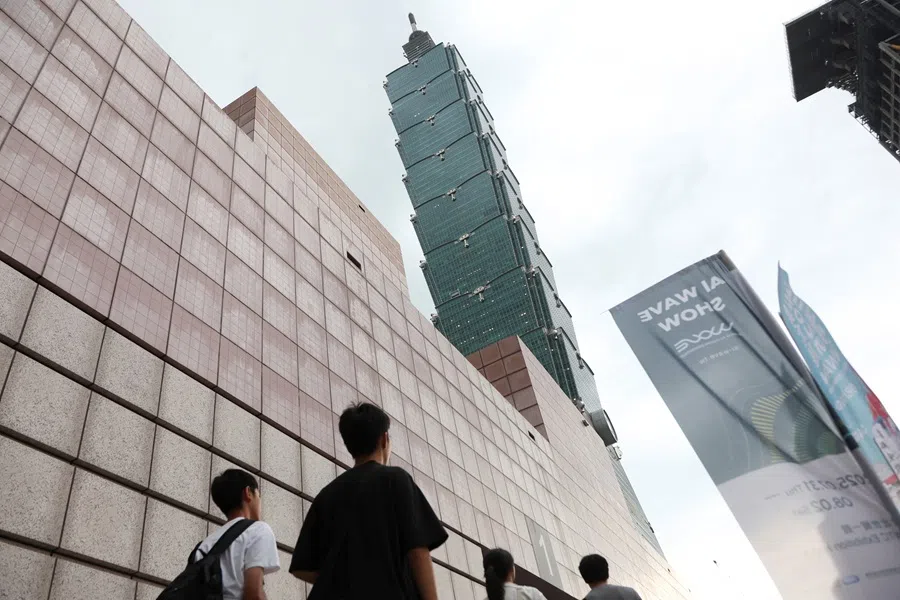 People walk past the Taipei 101 skyscraper outside the Taipei World Trade Center, the venue of the World AI Vision Exhibition, also known as AI WAVE SHOW, in Taipei, Taiwan, 1 August 2025.