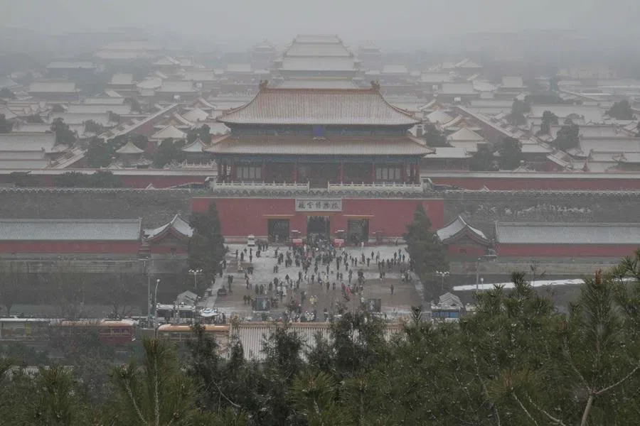 People visit the Forbidden City as snow falls in Beijing, China, on 12 December 2025. (Adek Berry/AFP)