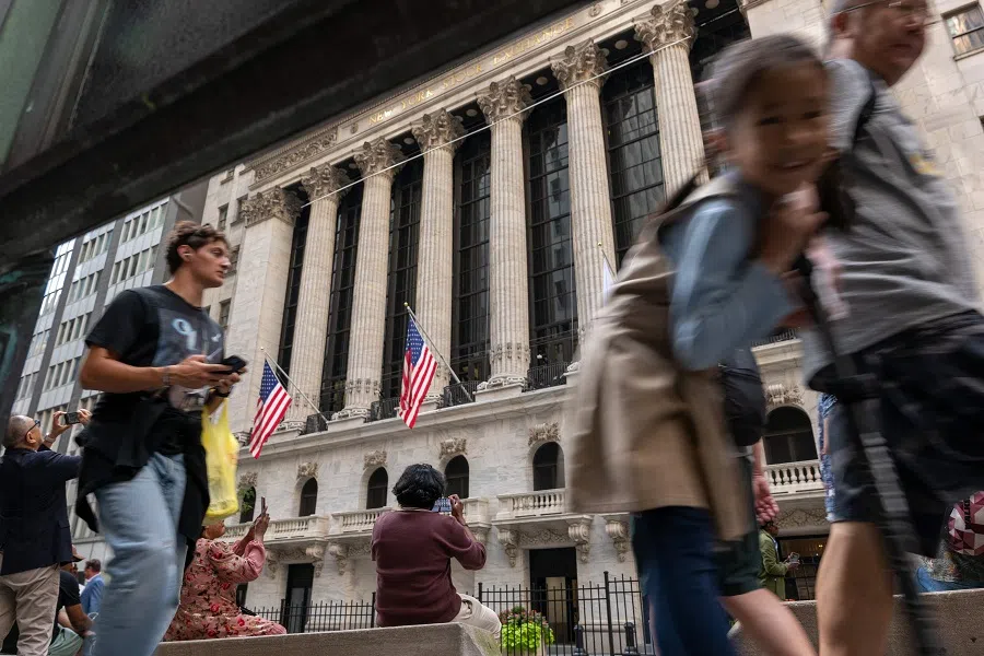 People walk through the financial district near the New York Stock Exchange (NYSE) on 19 September 2024, in New York City.