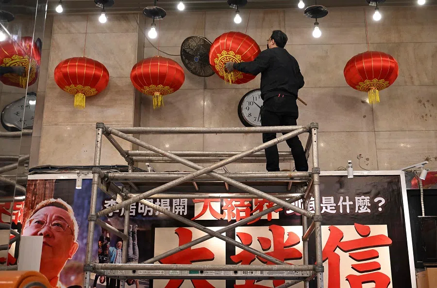 This picture taken on 31 January 2025 shows an an employee dusting the lanterns at the entrance of the Sunbeam Theatre in Hong Kong. A landmark Hong Kong venue that became synonymous with Cantonese opera for over half a century the Sunbeam Theatre closed its doors on 3 March 2025, with hundreds gathering to watch its neon signs going dark.