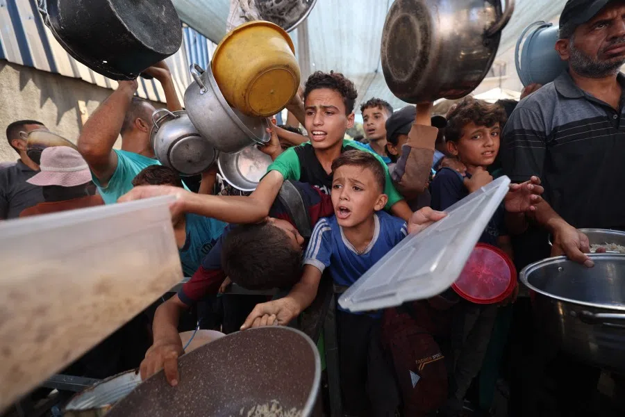 Palestinians queue to receive a hot meal from a charity kitchen in the Nuseirat refugee camp in the Israel-besieged Gaza Strip on 11 September 2025, amid a UN-declared famine after nearly two years of war.