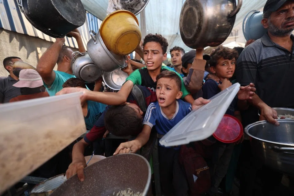 Palestinians queue to receive a hot meal from a charity kitchen in the Nuseirat refugee camp in the Israel-besieged Gaza Strip on 11 September 2025, amid a UN-declared famine after nearly two years of war. (Eyad Baba/AFP)
