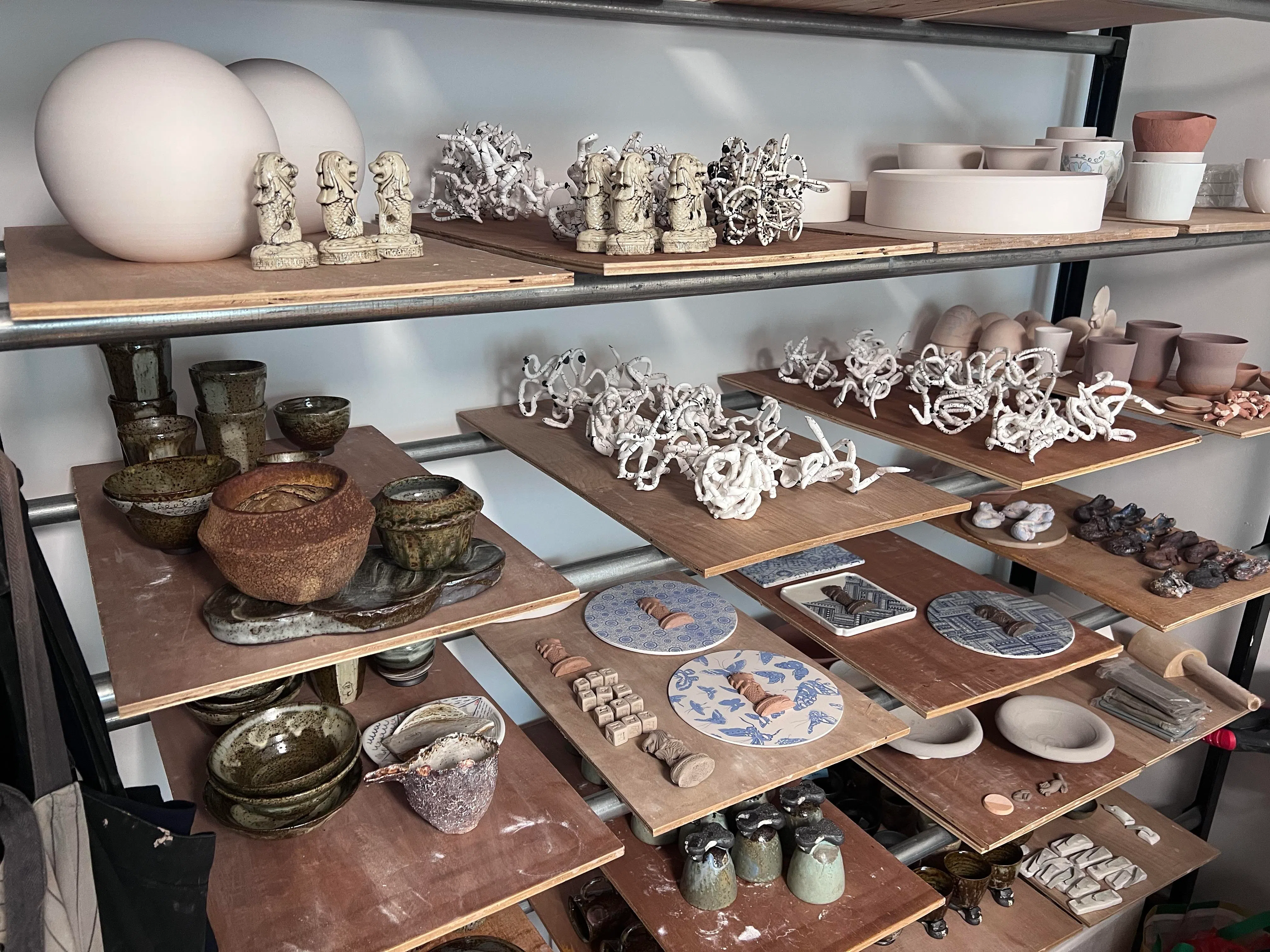 Some of Nelson’s smaller works, including ceramic Merlion souvenirs.