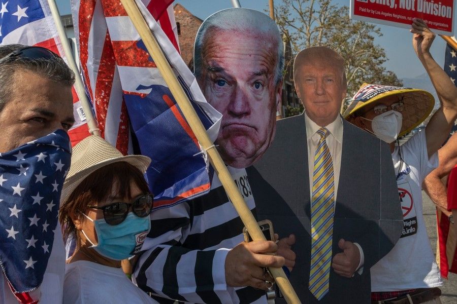 A man wears a striped prisoner costume and Joe Biden mask as supporters of the US President, who is being treated for Covid-19, rally for his reelection in Glendale, California, on 4 October 2020. (David McNew/AFP)