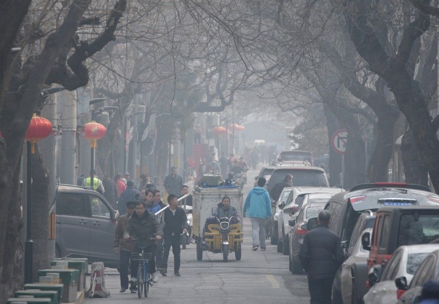 People are seen in a traditional alleyway, or Hutong, on a polluted day in central Beijing. (Jason Lee/REUTERS)