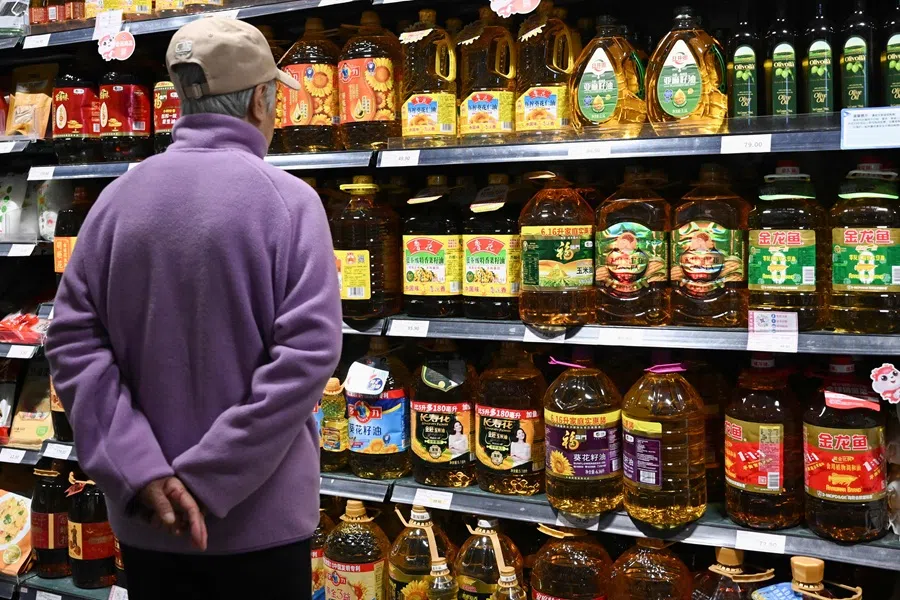 A shopper looks at various brands of cooking oil for sale at a supermarket in Beijing, China on 15 October 2025. (Pedro Pardo/AFP)