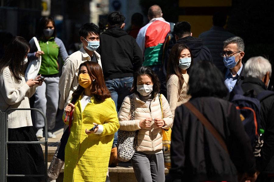 People wear masks on a street in Hong Kong, China, on 27 February 2023. (Peter Parks/AFP)