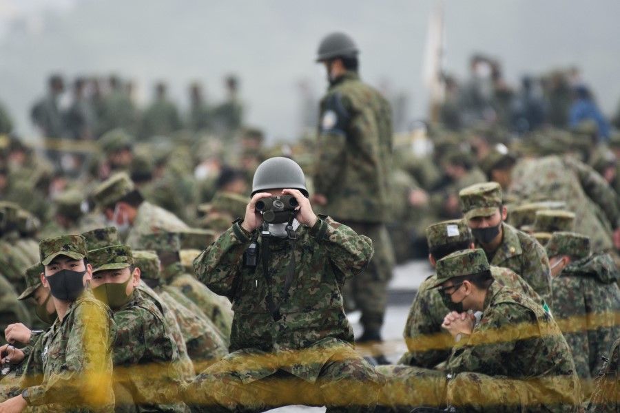A Japan's Ground Self-Defense Forces (JGSDF) soldier uses binoculars during a live fire exercise at JGSDF's training grounds in the East Fuji Maneuver Area in Gotemba, Japan on 22 May 2021. (Akio Kon/Bloomberg)