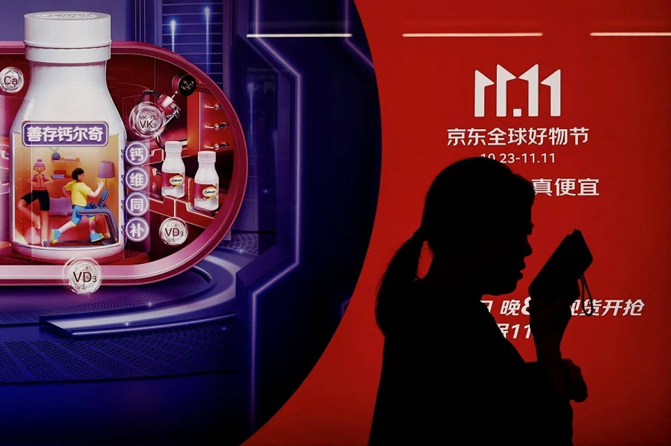 A person walks past a JD.com advertisement promoting the Singles' Day shopping festival, at a subway station in Beijing, China, on 26 October 2023. (Tingshu Wang/Reuters)