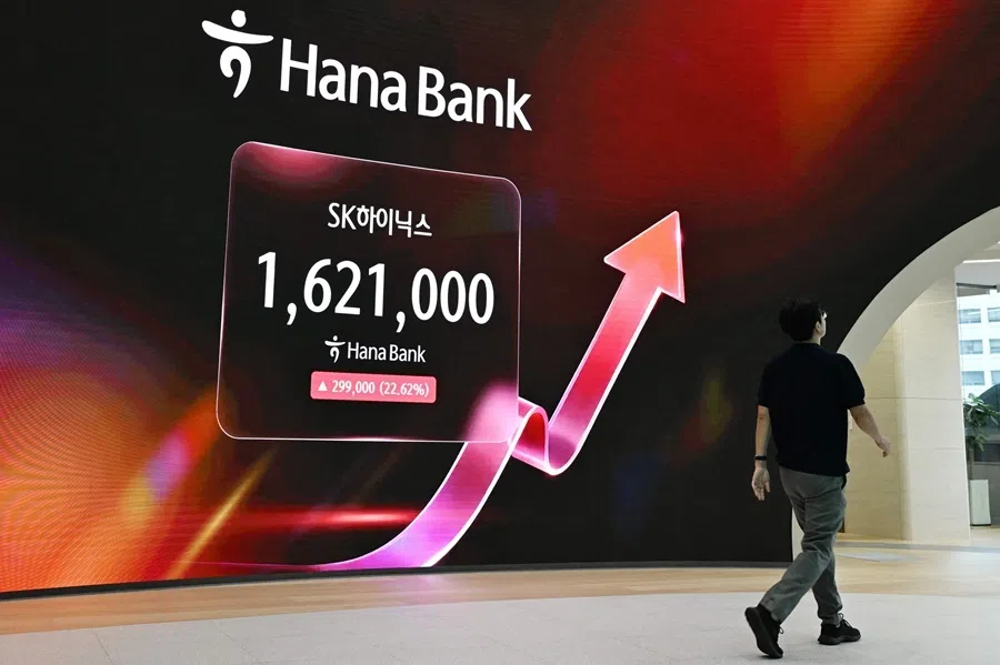 A man walks past an electronic screen showing the SK Hynix stock price outside a foreign exchange dealing room at the Hana Bank headquarters in Seoul on 31 July 2026.  South Korean stocks jumped 13% at open on 31 July with tentpole AI chipmaker SK hynix surging 20%, rebounding after a week of bruising losses.