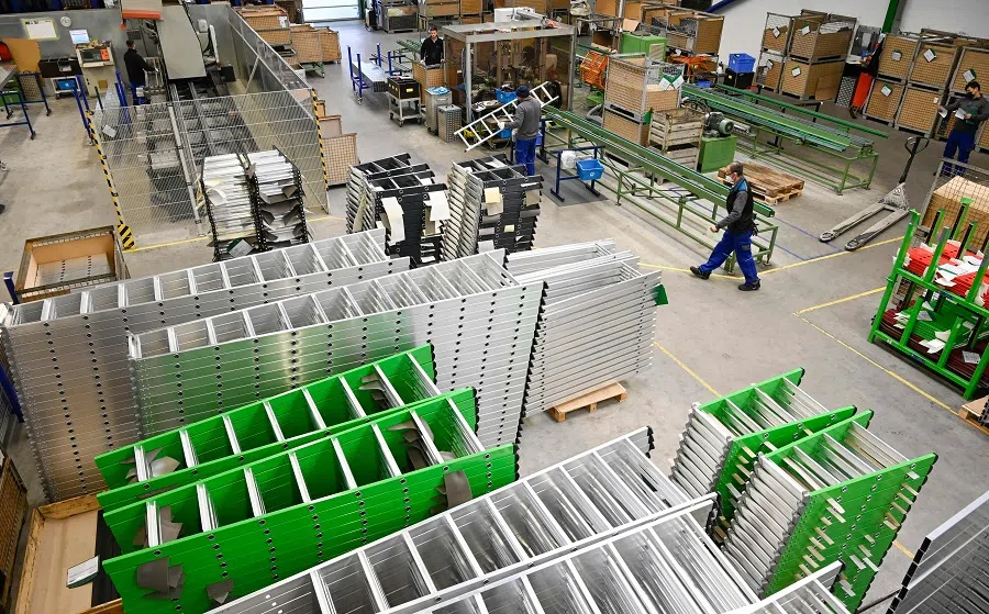 Employees work in a production hall of German ladder, stool and scaffold-maker Guenzburger Steigtechnik, at the company's headquarters in Günzburg, Germany, on 25 January 2022. (Thomas Kienzle/AFP)