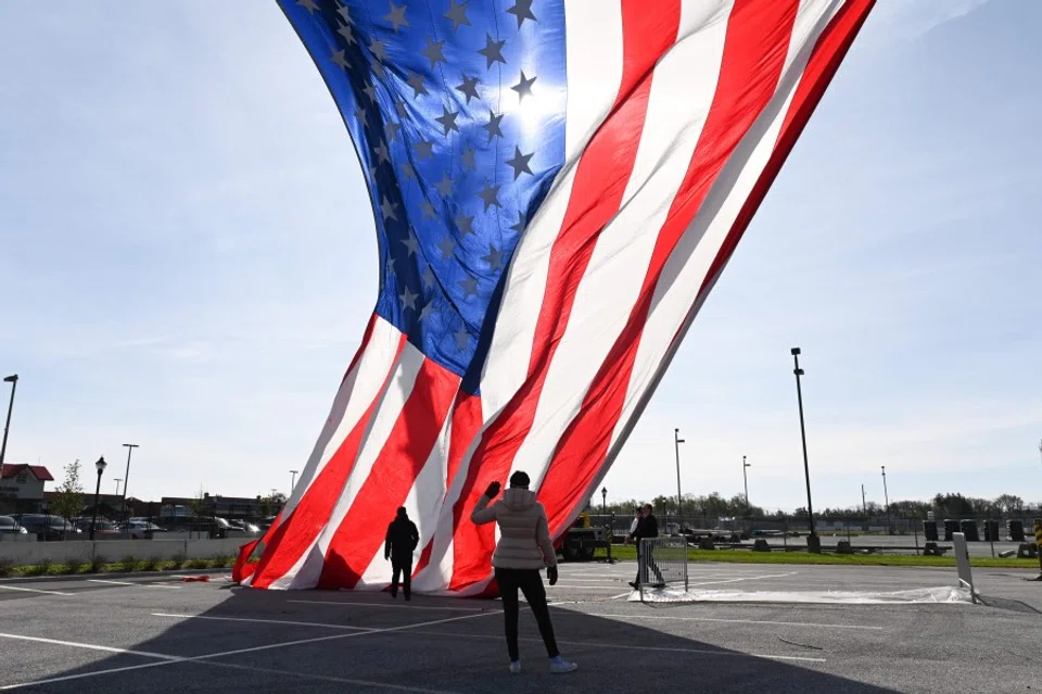 A US flag being hoisted on cranes outside the Chase Center in Wilmington, Delaware on 3 November 2020. (Roberto Schmidt/AFP)
