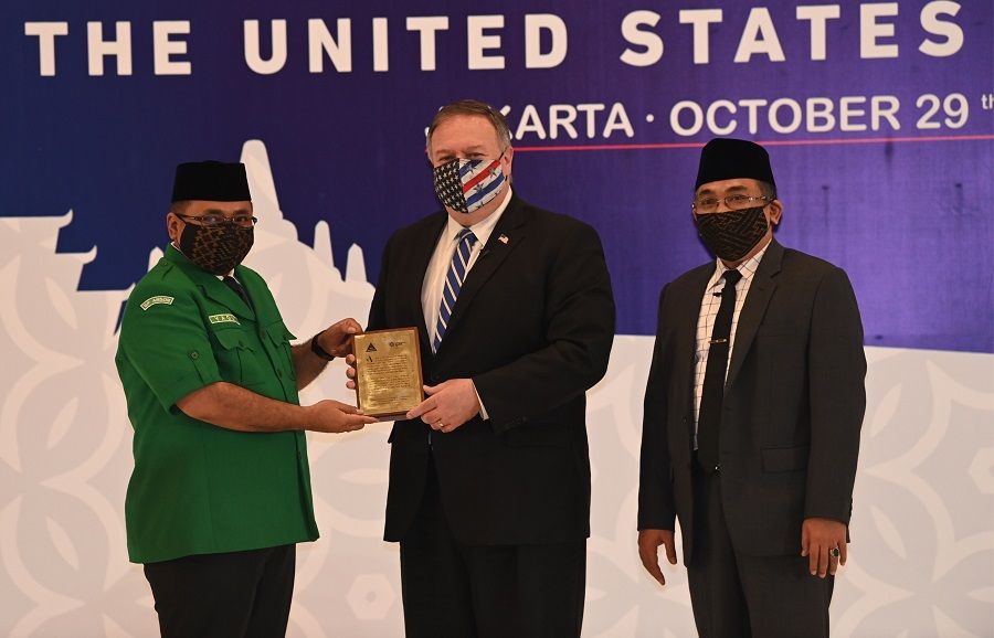 Then-US Secretary of State Michael Pompeo (centre) receives a placard from Yaqut Qoumas (left) General Chairman of Gerakan Pemuda Ansor next to Yahya Cholil Staquf (right) General Secretary of Nahdlatul Ulama at the Nahdlatul Ulama in Jakarta on 29 October 2020. (Adek Berry/Pool/AFP)
