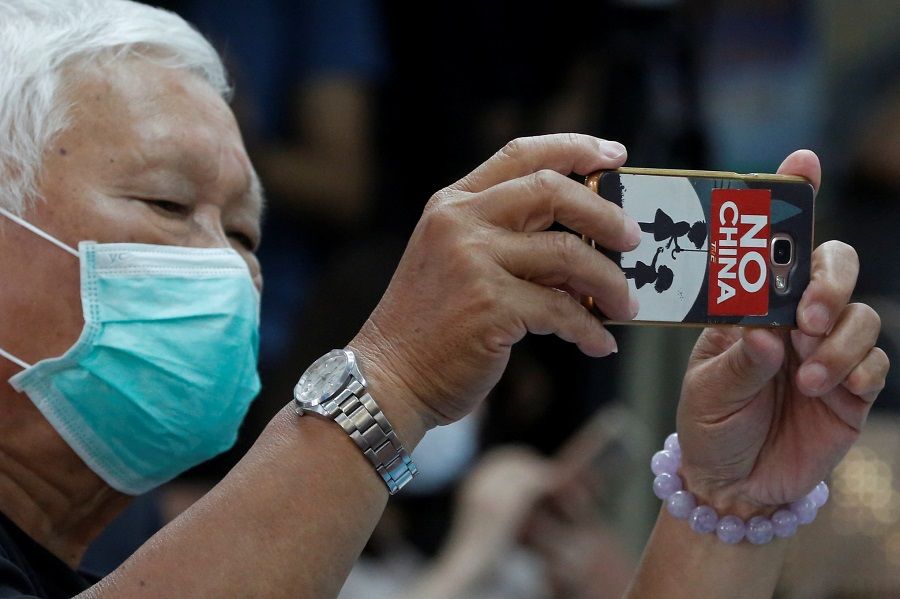 A man with a "No China" sticker on his phone is seen at a press conference pertaining to Taiwan's efforts to get into the World Health Organization in Taipei, Taiwan, on 15 May 2020. (Ann Wang/Reuters)