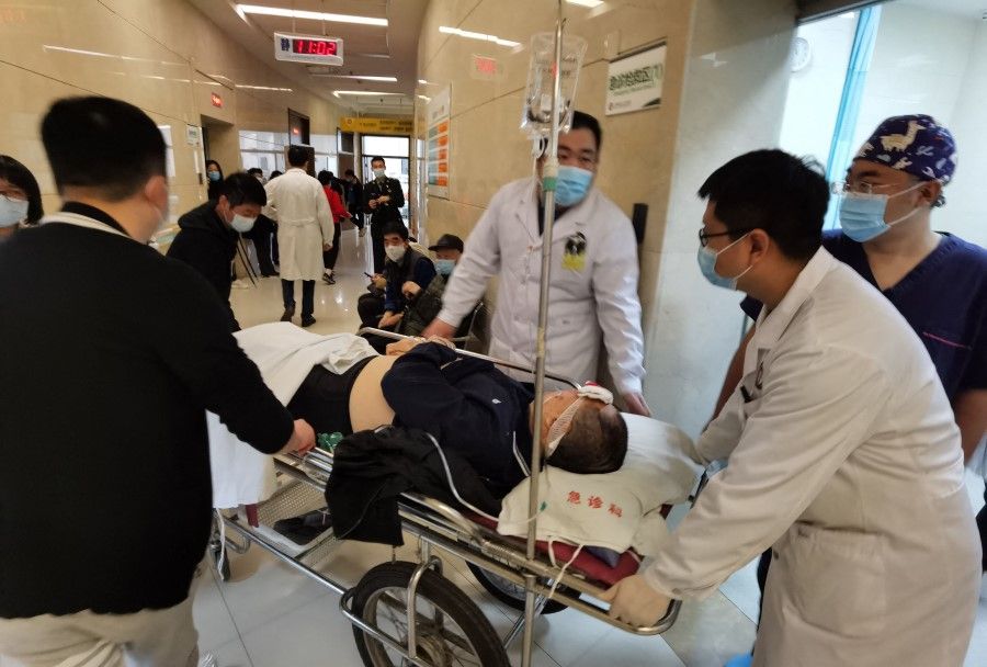 Medical workers wheel a patient at a hospital in Shenyang, China's northeastern Liaoning province, on 21 October 2021. (AFP)
