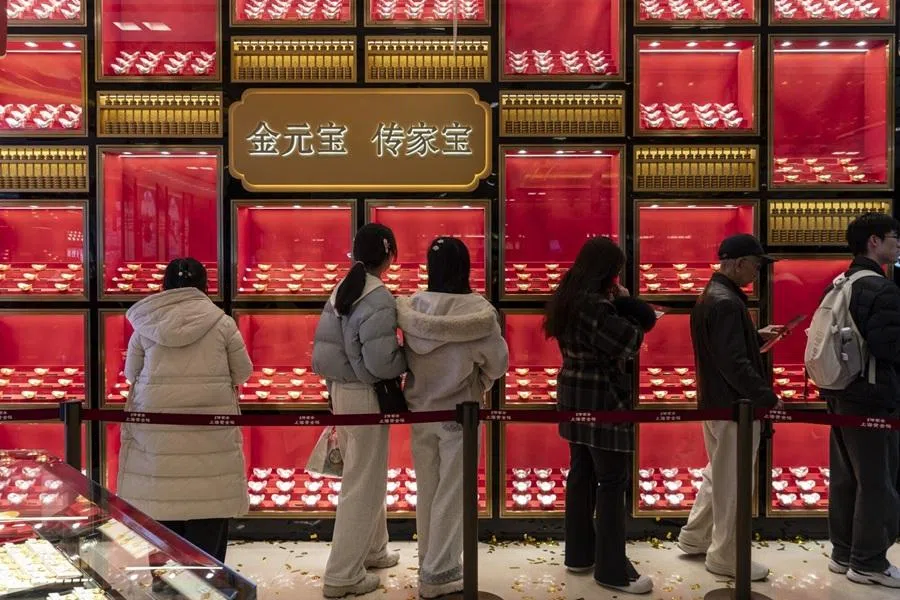 Shoppers look at gold products at a gold store in Shanghai, China, on 19 February 2026. (Qilai Shen/Bloomberg)