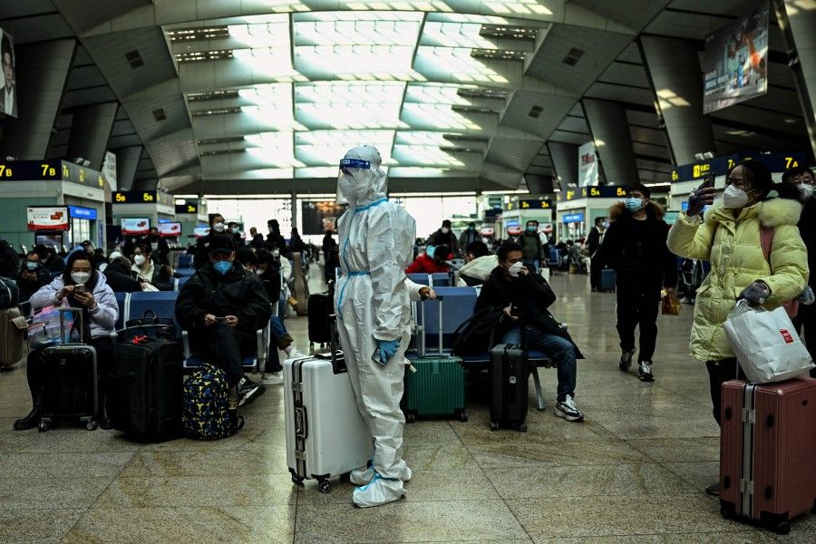 A passenger wearing protective gear is seen at a train station in Beijing, China, on 28 December 2022. (Noel Celis/AFP)