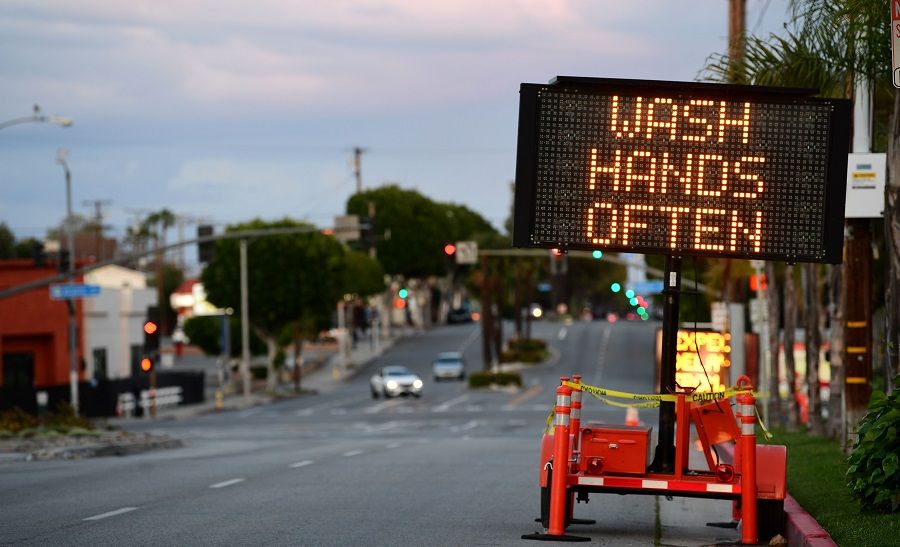 A sign reminds residents to 'Wash Hands Often' on the quiet streets of Monterey Park, California, on 26 March 2020 as people stay at home due to the Covid-19 pandemic. (Frederic J. Brown/AFP)