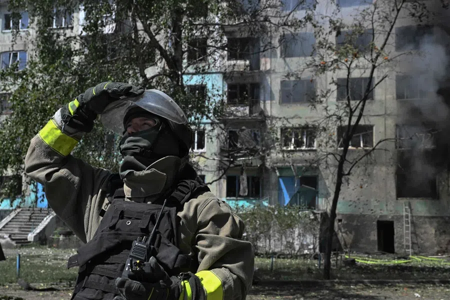 A Ukrainian firefighter checks the sky for enemy drones at the site of a Russian drone strike in the town of Bilozerske, Donetsk region on 10 August 2025, amid the Russian invasion of Ukraine. (Genya Savilov/AFP)