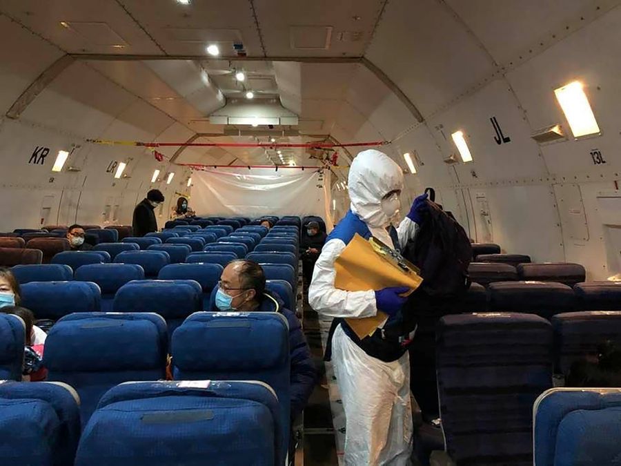 Staff from the US embassy walk in a cargo plane chartered by the US State Department to evacuate Americans and Canadians from China. (Courtesy of Edward Wang via Reuters)