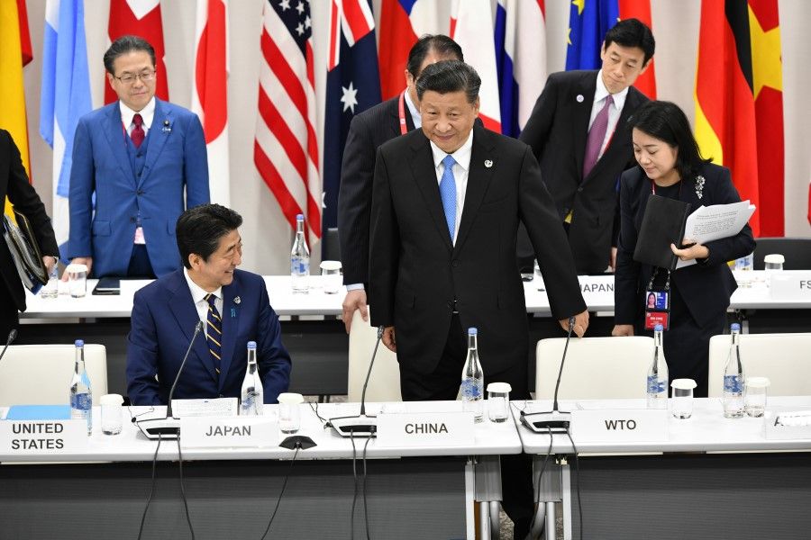 Japanese Prime Minister Shinzo Abe (L) and Chinese President Xi Jinping attend the first working session of the G20 Summit in Osaka, 28 June 2019. (G20 OSAKA)