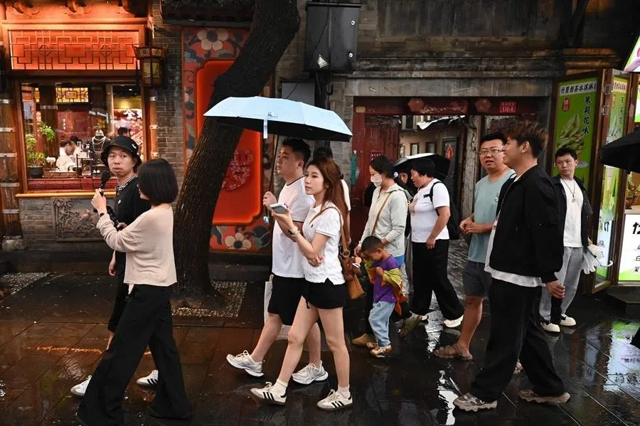 People walk in a popular tourist alley in Beijing on 19 June 2026.