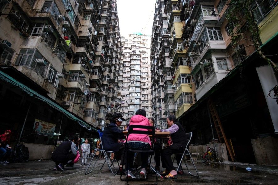 Women play cards in a living quarter of dense buildings in Kowloon, Hong Kong, 2019. (iStock)