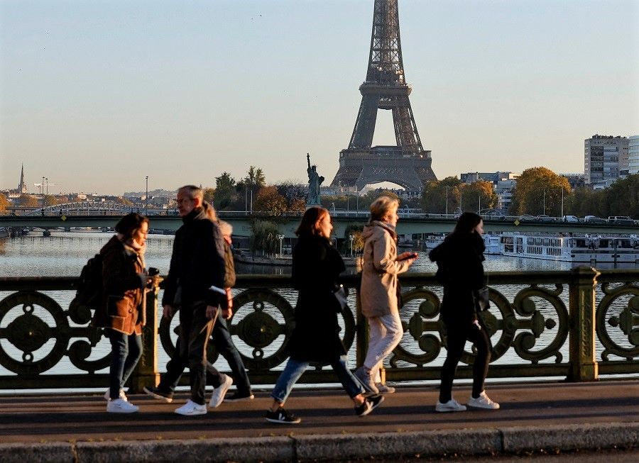 People walk near the Eiffel Tower in Paris, France, 10 November 2022. (Gonzalo Fuentes/Reuters)