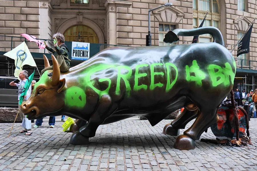 Climate activists hold a protest at the Charging Bull statue in Bowling Green near the New York Stock Exchange on 22 April 2025 in New York City. (Michael M. Santiago/AFP)