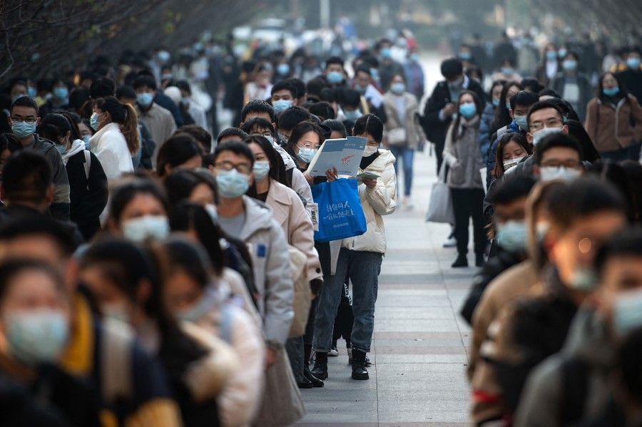 This photo taken on 28 November 2021 shows candidates queueing to take the national examination for admissions to the civil service in Wuhan in China's central Hubei province. (AFP)