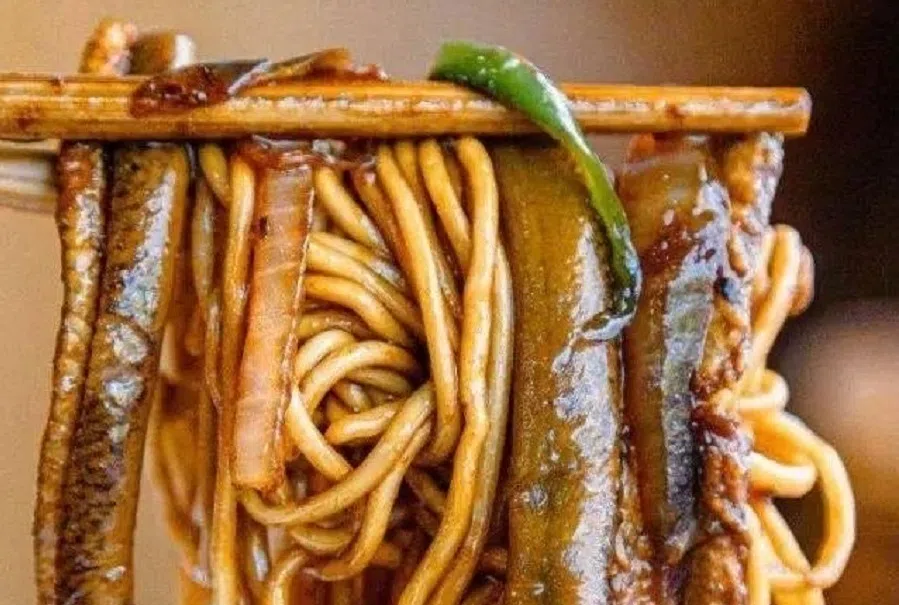 Delicious dry eel noodles come with a bowl of eel soup.