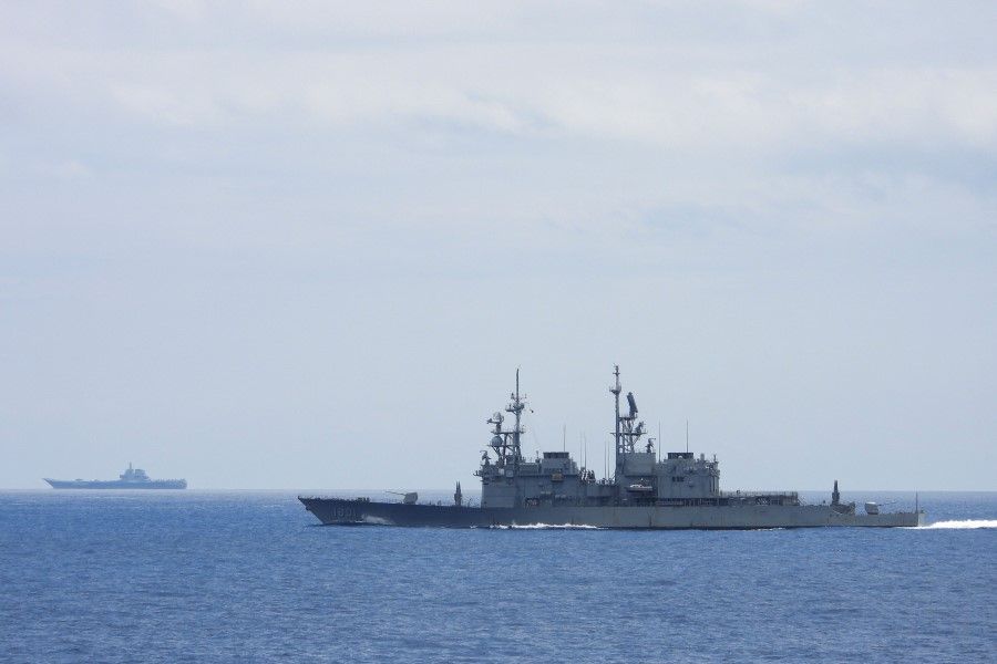 This undated handout photo released by the Taiwan Defence Ministry on 13 September 2023 shows Chinese aircraft carrier Shandong (left) while being monitored by a Taiwanese Keelung class warship at sea. (Handout/Taiwan Defense Ministry/AFP)