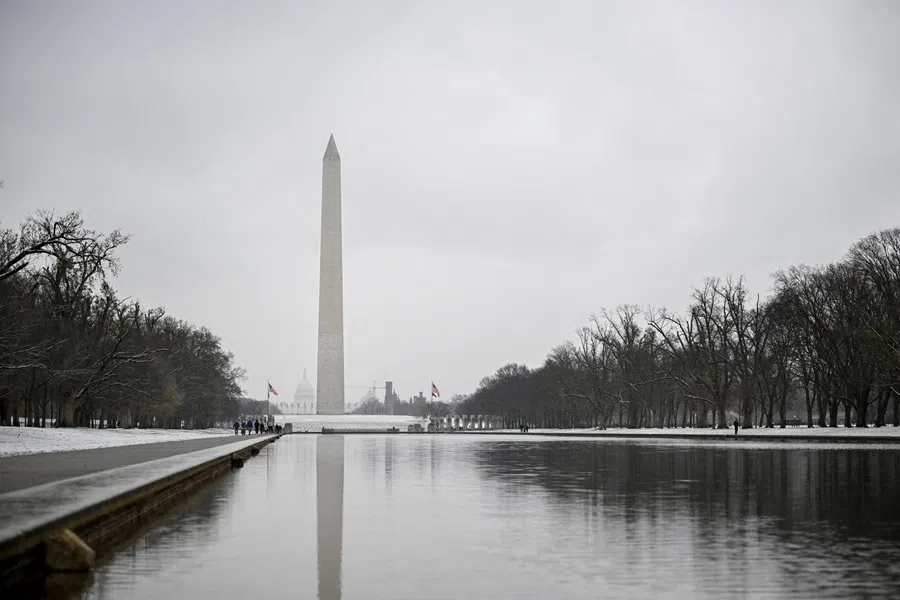 The Washington Monument and Capitol, seen from the reflecting pool near the Lincoln Memorial, stand as snow covers the National Mall in Washington, DC, US on 5 December 2025. (Daniel Heuer/Reuters)