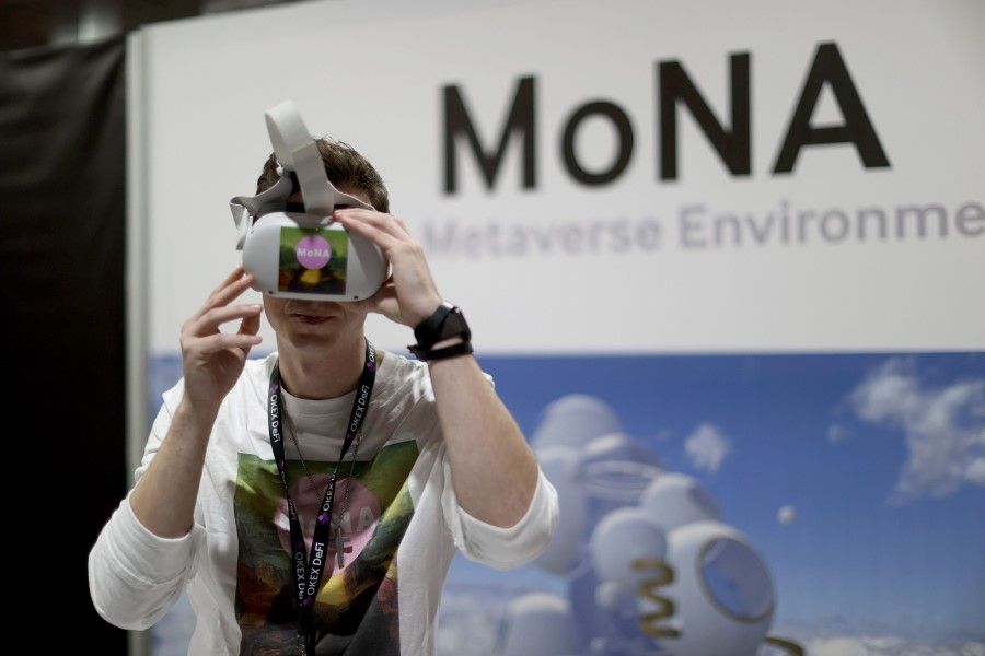 A man wears a VR headset at a booth during the DCentral Miami Conference at the Miami Airport Convention Centre on 1 December 2021 in Miami, Florida. (Joe Raedle/Getty Images/AFP)