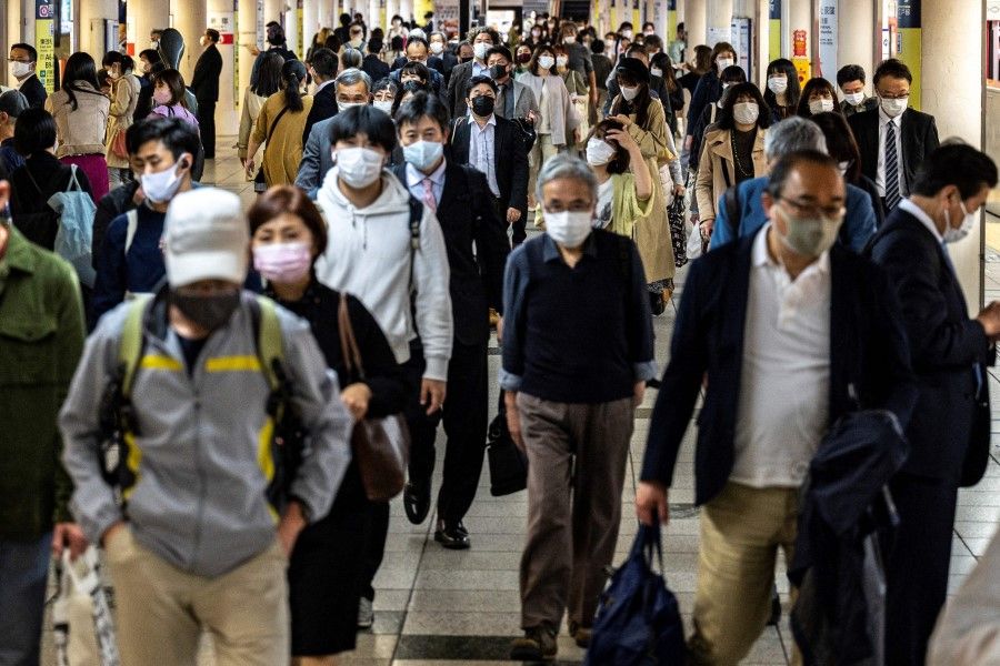 People walk through Shinjuku train station in Tokyo on 23 April 2021. (Charly Triballeau/AFP)