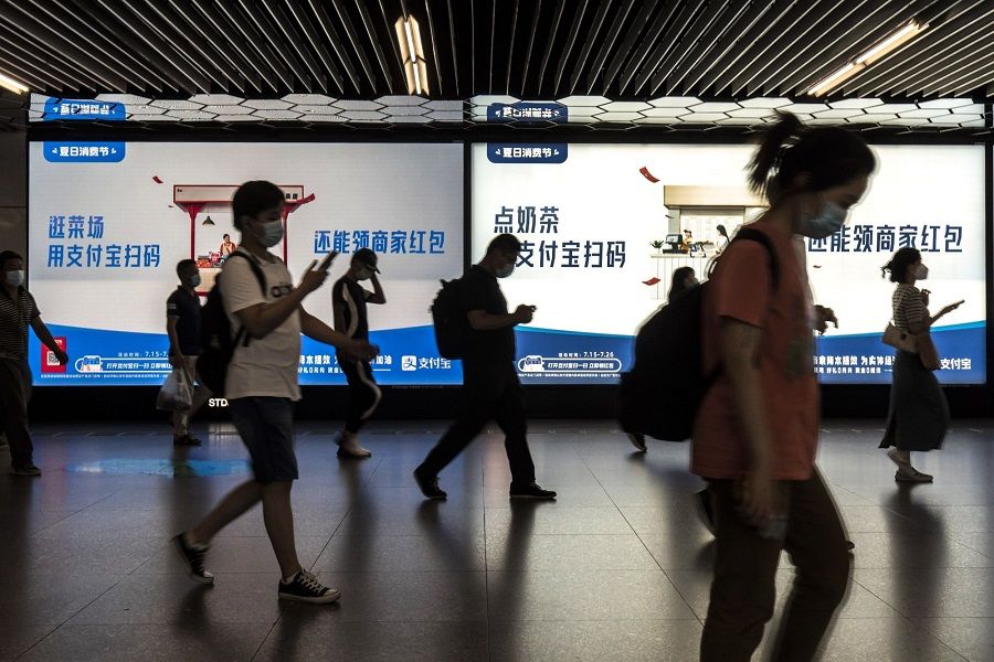 Commuters walk past advertisement at a subway station in Shanghai, China, on 28 July 2022. (Qilai Shen/Bloomberg)