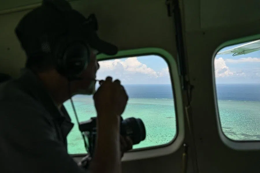 A Philippine Coast Guard personnel talks on a mic as he looks over Scarborough Shoal in the disputed South China Sea on 15 June 2026.